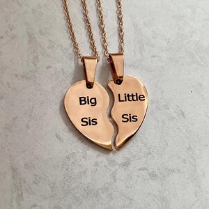May include: Two gold-tone necklaces with heart-shaped pendants that say "Big Sis" and "Little Sis".