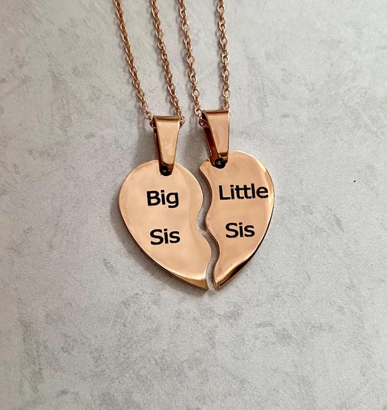 May include: Two gold-tone necklaces with heart-shaped pendants that say "Big Sis" and "Little Sis".