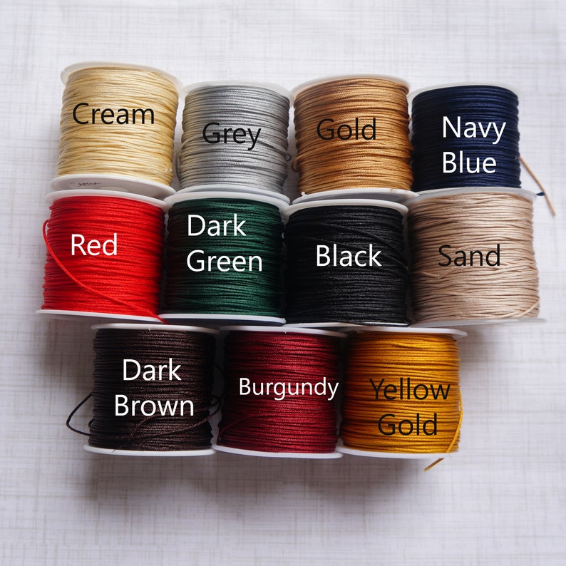 May include: Spools of waxed cotton cord in various colors, including cream, grey, gold, navy blue, red, dark green, black, sand, dark brown, burgundy, and yellow gold.