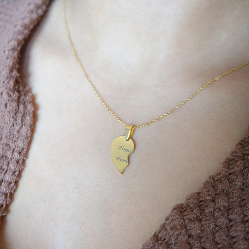 May include: Gold necklace with a heart-shaped pendant that says "Together forever".