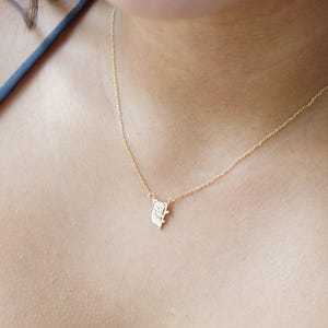 May include: A gold chain necklace with a small koala pendant. The koala is facing to the right and is holding onto a branch.
