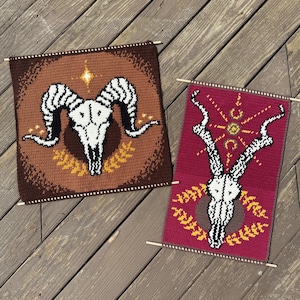 Peut inclure: Deux tentures murales faites à la main au crochet. L'une est marron avec un motif de crâne de bélier blanc, l'autre est bordeaux avec un motif de crâne de cerf blanc. Les deux ont des chevilles en bois pour accrocher et sont décorées d'accents dorés et jaunes.