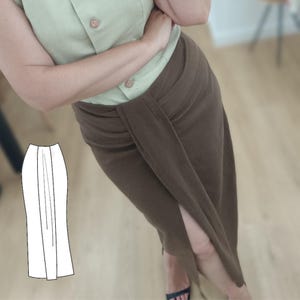 May include: A brown wrap skirt with a high slit, paired with a light green button-up shirt. The skirt has a knotted detail at the waist. A pattern illustration of the skirt is in the lower left corner.