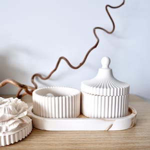 May include: A set of three ceramic mugs with a speckled, cream-colored glaze. Each mug features a different hand-painted floral design in shades of blue, green, and yellow. The mugs have a simple, modern shape.