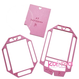 Può includere: Fustelle rosa A7 per realizzare biglietti con ritagli a forma di cuore. Una fustella è rettangolare con la scritta "A7 74x105MM". Altre due hanno la forma di un telaio con un cuore in alto. Il testo "Karma" è visibile.