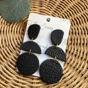 Texturerade örhängen i svart polymerlera: Lätt present