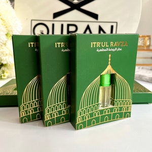 May include: Three green boxes with gold trim and a gold dome design. The boxes contain small bottles of perfume. The text on the boxes reads "ITRUL RAVZA عطر الروضة المطهرة" which translates to "ITRUL RAVZA The Perfume of the Holy Mosque".