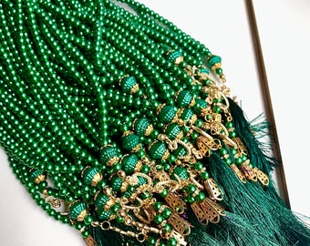 May include: A bundle of green prayer beads with gold accents and green tassels. The beads are strung on a thin cord and have a shiny finish.