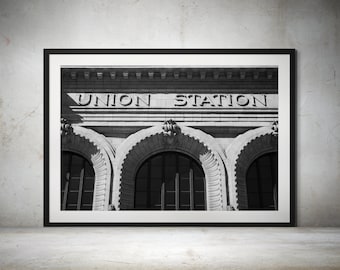 May include: Black and white photograph of a building with the words "UNION STATION" above three arched doorways.