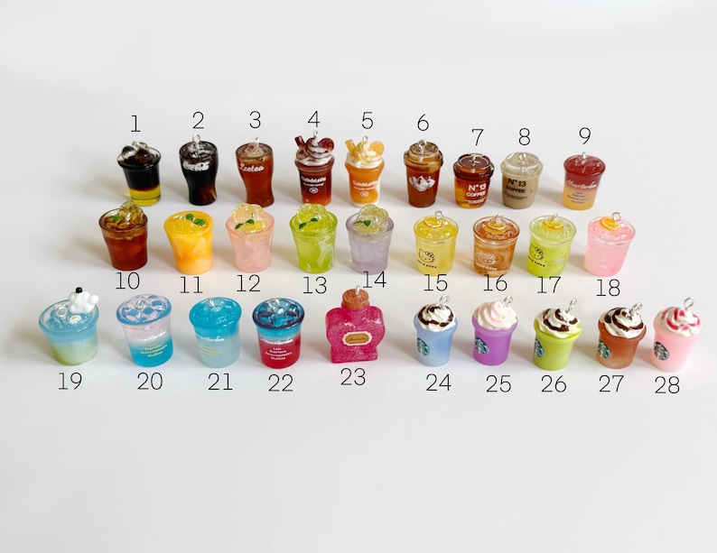 Puede incluir: Una colecci&oacute;n de veintiocho dijes de bebidas en miniatura dispuestos en tres filas, numerados del 1 al 28. Los dijes presentan varios dise&ntilde;os, incluyendo caf&eacute;s helados, bebidas con infusi&oacute;n de frutas y bebidas con crema batida.