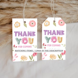 Pode incluir: Duas etiquetas de presente brancas com desenhos florais e as palavras "THANK YOU FOR COMING" em roxo, verde e laranja. As etiquetas t&ecirc;m um cord&atilde;o para pendurar e s&atilde;o decoradas com flores e folhas.
