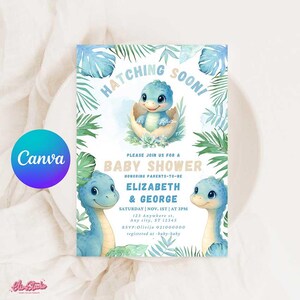 Può includere: Invito per baby shower con un dinosauro blu che esce da un uovo, circondato da foglie verdi e fogliame blu acquerello. L'invito include il testo "Hatching Soon!" e i dettagli per il baby shower di Elizabeth e George.