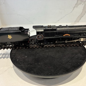 May include: A black model steam locomotive and tender set on a short section of train track. The engine features the number 46205 on the cab side and the name Princess Victoria on the side, with gold detailing and a coal load in the tender.