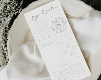 Könnte beinhalten: Eine weiße Karte mit dem Text "sip & solve" in eleganter Schrift, mit Wortsuch-, Labyrinth-, Tic-Tac-Toe- und Mad Libs-Spielen. Die Karte liegt auf einem weißen Teller mit einem weißen Tuch und einem dunkelgrünen Hintergrund.