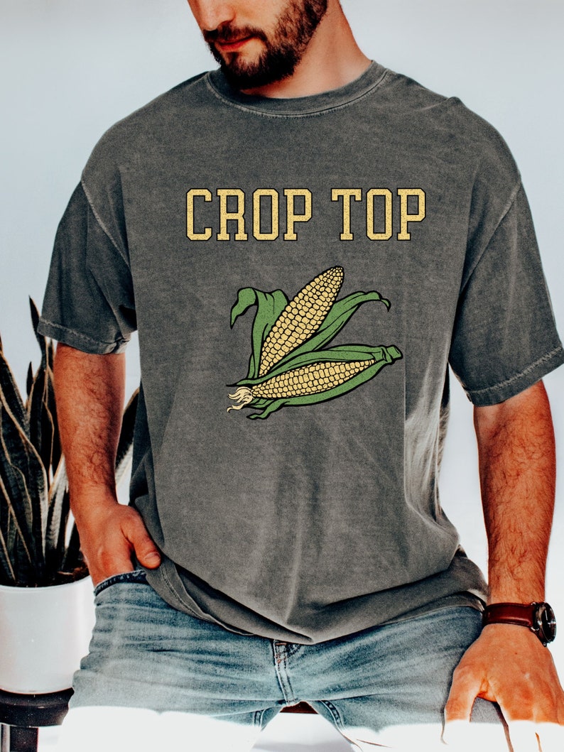May include: A gray t-shirt with the text "Crop Top" and a graphic of corn on the front.