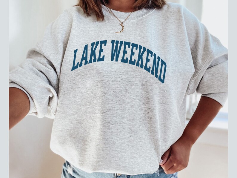 May include: Gray sweatshirt with the text "LAKE WEEKEND" in blue lettering.