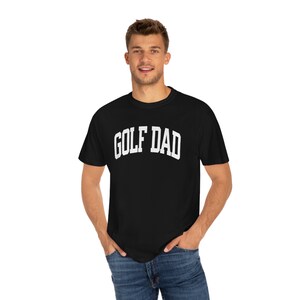 May include: A black t-shirt with white text that reads "GOLF DAD".