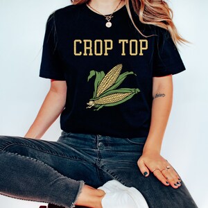 May include: A black crop top with the text "CROP TOP" in yellow letters and a green and yellow corn graphic.