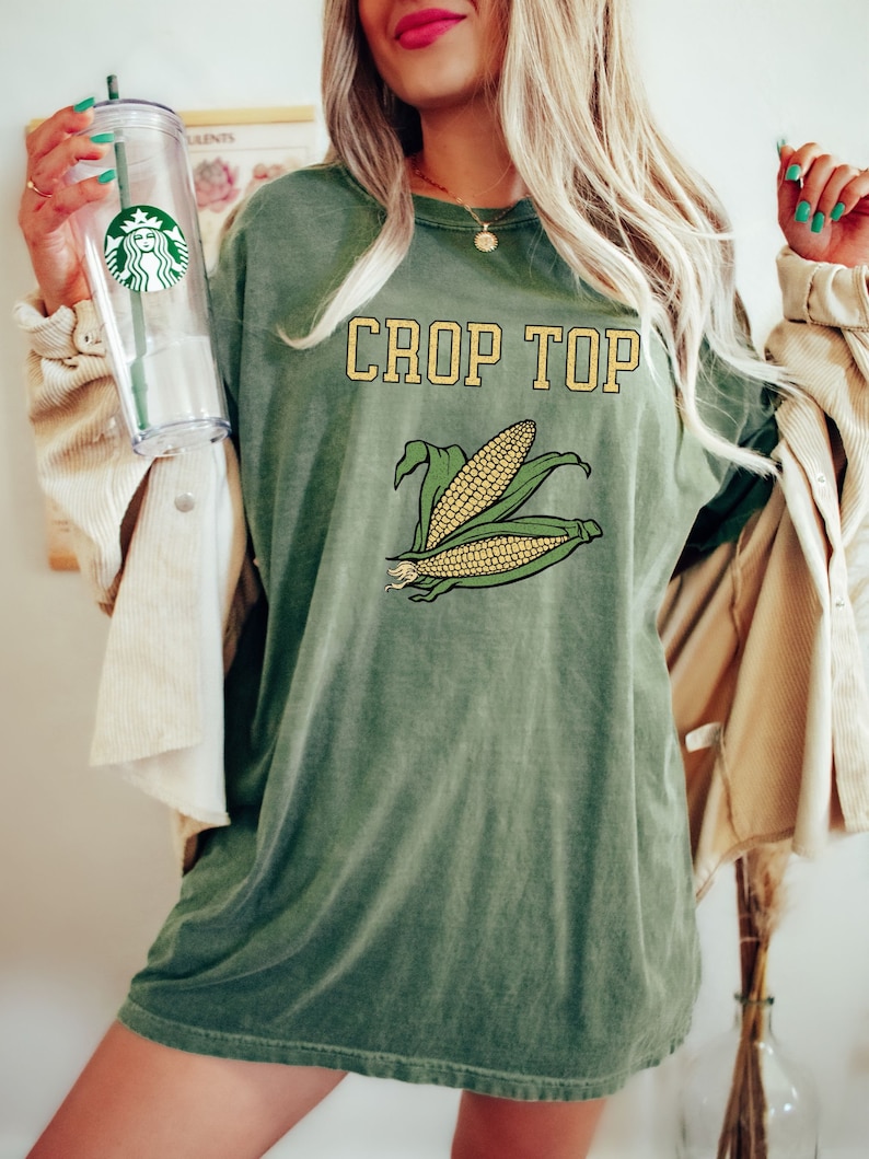 May include: A green oversized t-shirt with the text "CROP TOP" in yellow letters and a graphic of two ears of corn.