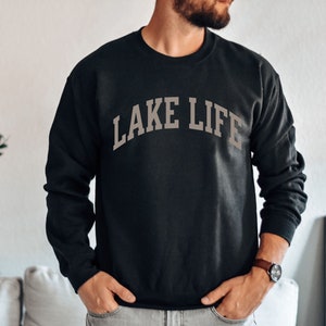 以下が含まれることがあります： グレーのアーチデザインで「LAKE LIFE」と書かれた黒いスウェットシャツです。