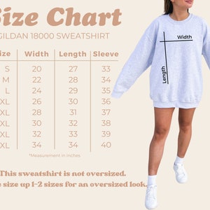 May include: Size chart for a Gildan 18000 sweatshirt, showing measurements in inches for width, length, and sleeve length for sizes S through 5XL. The chart states that the sweatshirt is not oversized and recommends sizing up 1-2 sizes for an oversized look.