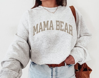 May include: A gray sweatshirt with the text "MAMA BEAR" in brown letters.