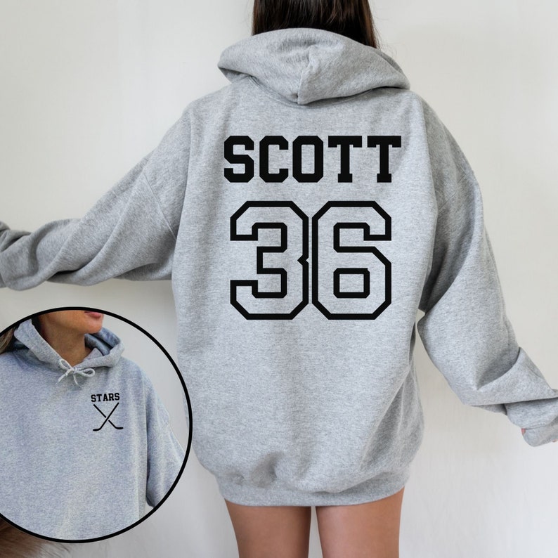 May include: Gray hooded sweatshirt with the name "SCOTT" and the number "36" printed on the back. The front of the sweatshirt has a small graphic of crossed hockey sticks with the word "STARS" above them.