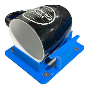 May include: A blue plastic mug holder with a black mug that says "Engraving Proof" on it.