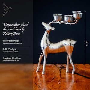 May include: A silver-plated deer candelabra by Pottery Barn with six tealight holders on its antlers. The sculptural deer stands 11.5 inches tall and measures 9 inches wide. The text reads: Vintage silver-plated deer candelabra by Pottery Barn.