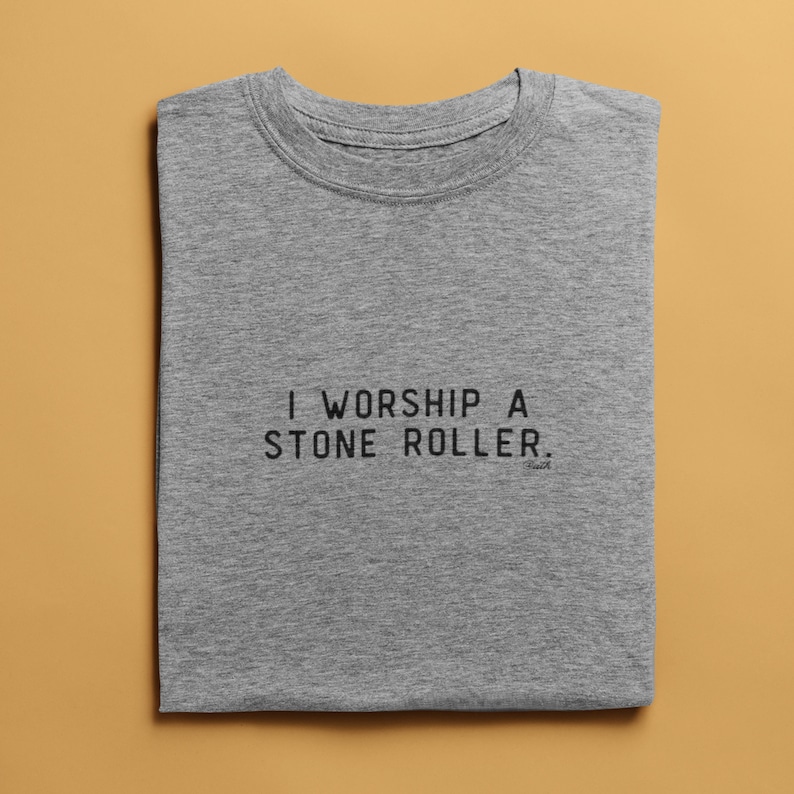 May include: A grey t-shirt with the text "I worship a stone roller." printed on the front.