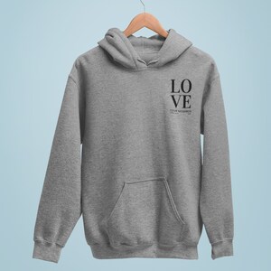 May include: A gray hooded sweatshirt with the words "LOVE YOUR NEIGHBOR" printed on the front in black.