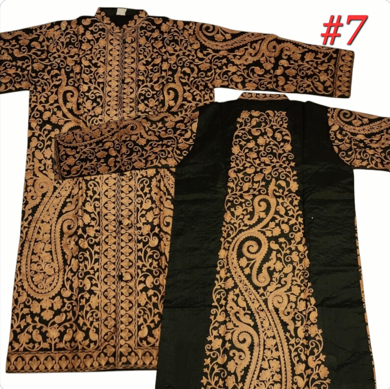 Op de afbeelding: Zwart en goud geborduurde tuniek met lange mouwen. De tuniek heeft ingewikkelde bloemen- en paisley-patronen. Het kledingstuk wordt getoond met de voor- en achterkant zichtbaar, waarbij het gedetailleerde ontwerp wordt benadrukt. Het nummer 7 is rechtsboven zichtbaar.