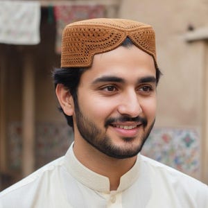 May include: A brown, intricately patterned cap with a rounded crown and a distinctive front design. The cap is made of a woven material and is worn by a person wearing a cream-colored shirt.