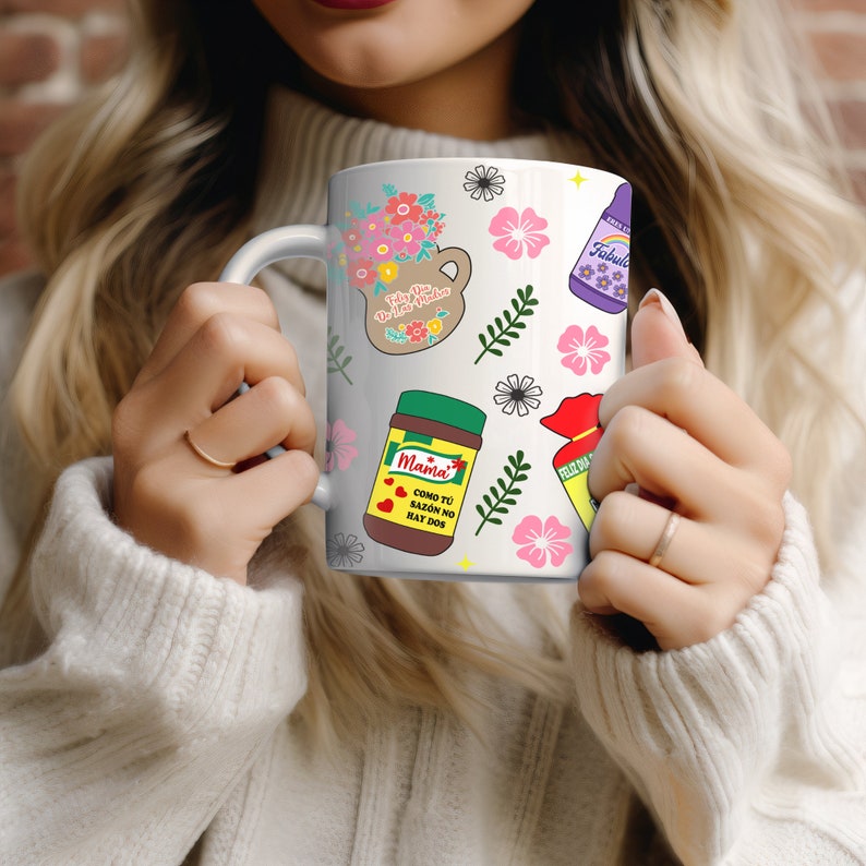 May include: White ceramic mug with a colorful design featuring flowers, a jar of Mama's seasoning, a bottle of Fabuloso cleaner, and a red pouch with the text "Feliz Dia de las Madres".