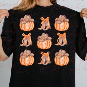 May include: A black t-shirt with a repeating pattern of orange pumpkins with brown cowboy hats and brown cowboy boots with yellow bows.