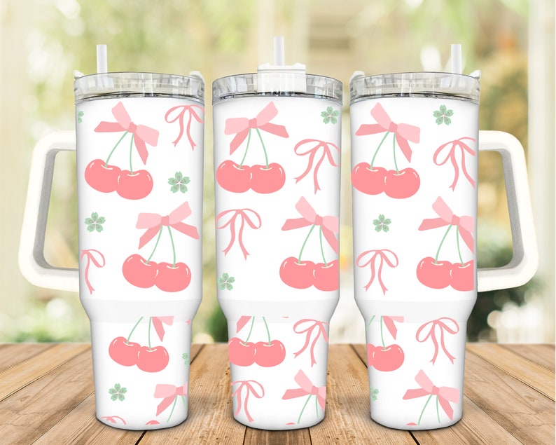 May include: Three white stainless steel tumblers with pink cherry and bow designs. The tumblers have clear lids and straws. The tumblers have handles.
