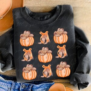 May include: A black sweatshirt with a repeating pattern of orange pumpkins with brown cowboy hats and brown boots with a brown bow.