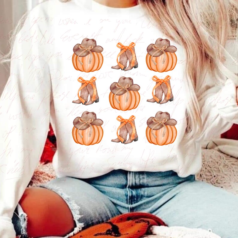 May include: White sweatshirt with a repeated pattern of orange pumpkins with brown cowboy hats and brown cowboy boots with orange bows.