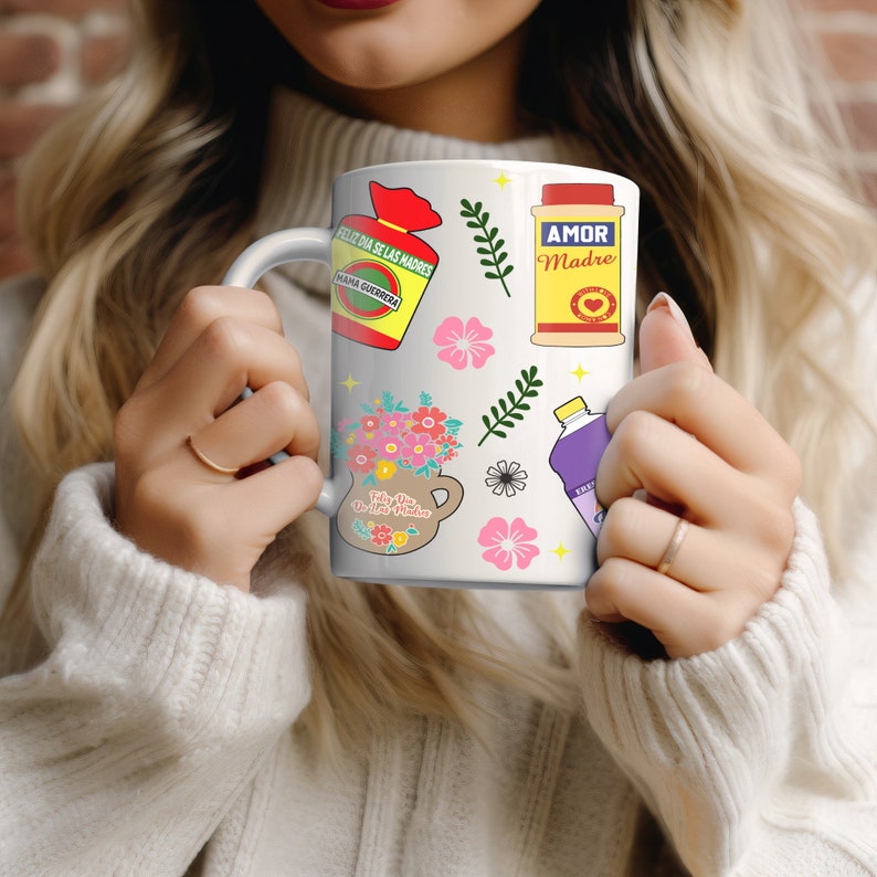 May include: White ceramic mug with a colorful design featuring flowers, a jar of salsa, a bottle of cleaning solution, and a box of crackers. The mug has the text "Feliz Dia de las Madres" and "Mama Querida" on the box of crackers. The bottle of cleaning solution has the text "Frijol" on it. The jar of salsa has the text "Amor Madre" on it.