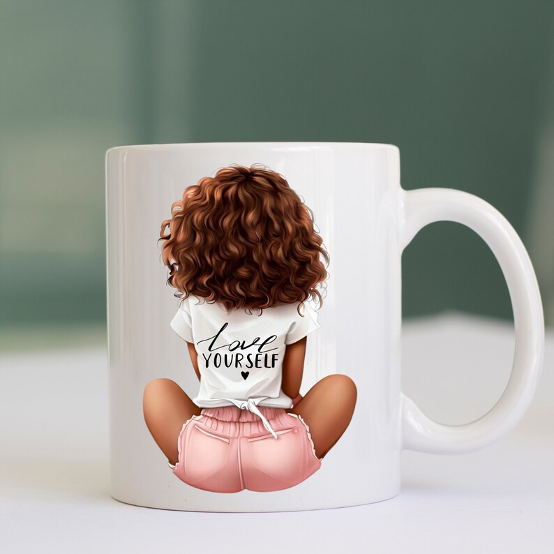 May include: White ceramic mug with a graphic of a woman with brown curly hair sitting with her legs crossed. She is wearing a white t-shirt with the text "love yourself" and pink shorts.