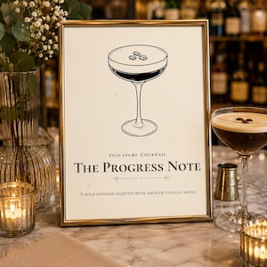 May include: A gold-framed sign featuring a black line drawing of a cocktail glass with three coffee beans on top. The text reads: Signature Cocktail, The Progress Note, A bold espresso martini with smooth vanilla notes. The sign is on a table.