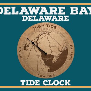 Puede incluir: Un reloj de marea de madera con un mapa de la bahía de Delaware con las palabras "HIGH TIDE", "LOW TIDE", "RISING" y "FALLING" alrededor del borde. La esfera del reloj también incluye los nombres de ciudades y pueblos de la zona, como Filadelfia, Vineland, Dover, Cape May y Lewes.