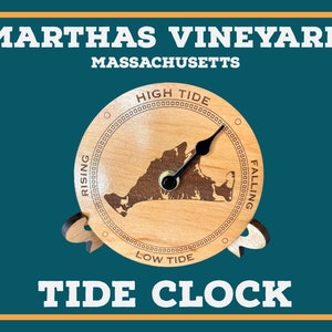Puede incluir: Un reloj de marea de madera con un mapa de Martha's Vineyard, Massachusetts. La esfera del reloj tiene las palabras "High Tide" y "Low Tide" y las palabras "Rising" y "Falling" a cada lado del mapa. El reloj tiene una aguja negra que apunta al nivel de la marea actual.