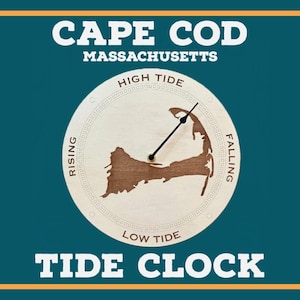 Puede incluir: Un reloj de marea de madera con un mapa de Cape Cod, Massachusetts. La esfera del reloj muestra la marea alta, la marea baja, la marea creciente y la marea decreciente. Las manecillas del reloj son negras y apuntan al nivel de la marea actual.