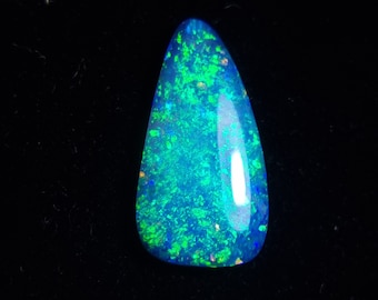May include: A teardrop-shaped blue and green opal gemstone with a high polish. The opal has a bright, iridescent sheen.