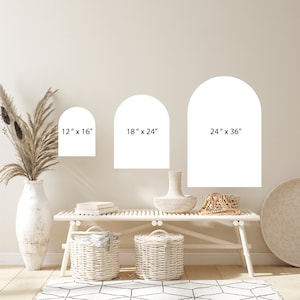May include: Three white arch-shaped wall decals in different sizes: 12" x 16", 18" x 24", and 24" x 36". The decals are shown on a light beige wall above a white bench with two white wicker baskets.