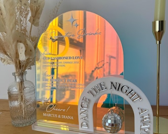May include: White acrylic sign with a mirrored arch and a disco ball hanging from it. The sign says "Dance the Night Away!" and "Cheers! Marcus & Diana".