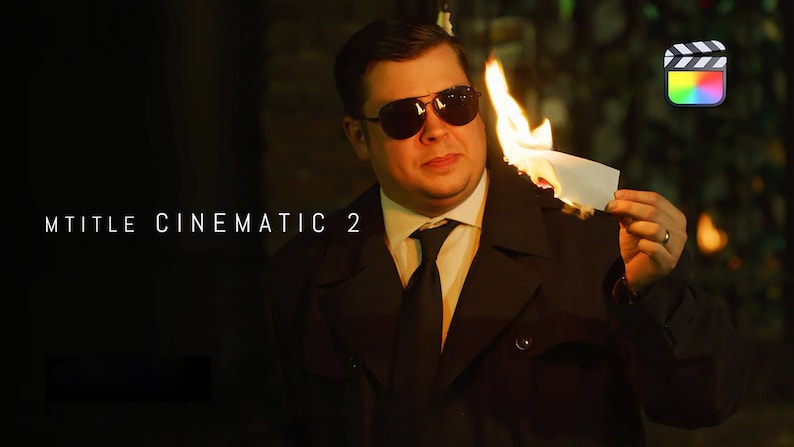 May include: A man in a black suit and sunglasses holds a piece of paper on fire. The text "MTITLE CINEMATIC 2" is visible in the background.