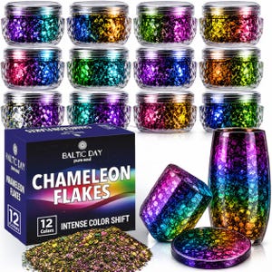 May include: Twelve small clear jars filled with iridescent chameleon flakes in various colors, arranged above a dark blue box labeled Baltic Day Chameleon Flakes with 12 colors, alongside a pile of loose flakes and two glass containers.