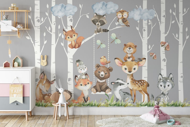 May include: A gray and white woodland nursery wall mural with a variety of animals including a fox, deer, bear, owl, raccoon, and wolf. The mural features birch trees and clouds.